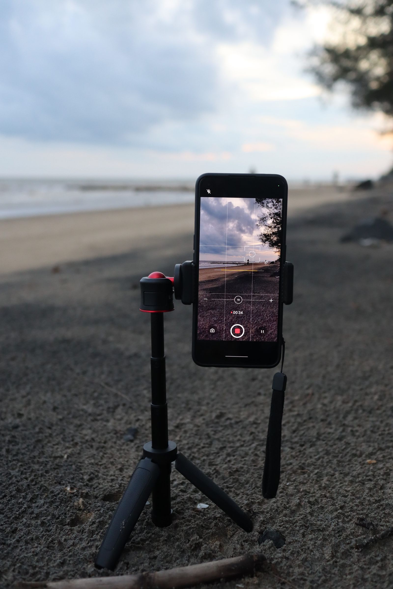 小型三脚に縦向きでスマートフォンを固定し、動画を撮影している様子